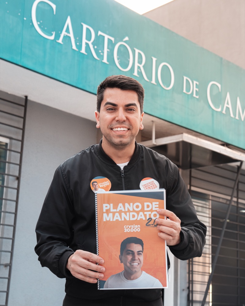 Cryslan segurando o Plano de Mandato 2.0 em frente ao cartório