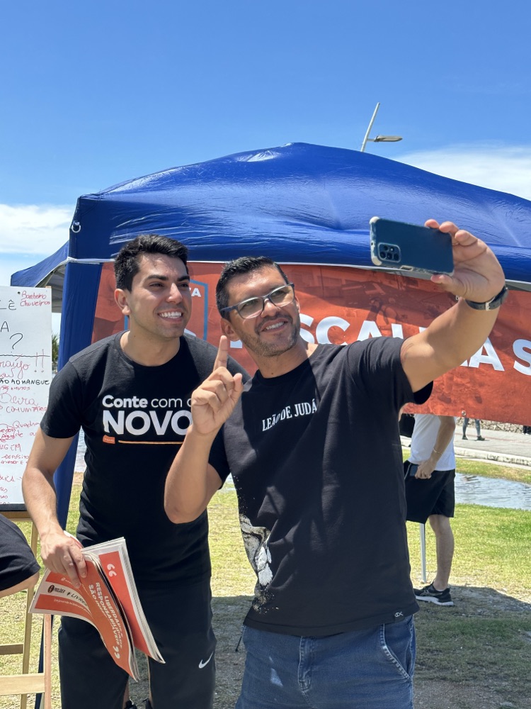 Cryslan com apoiador durante ação de escuta na comunidade
